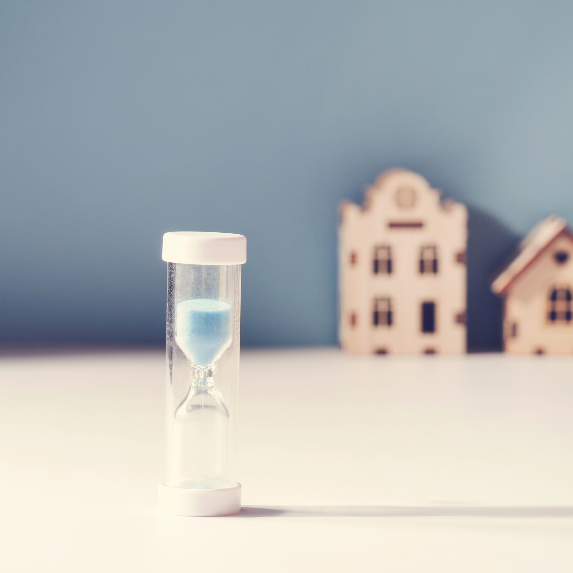 housing mortgage, property market ,demand for real estate concept. hourglass and small toy houses