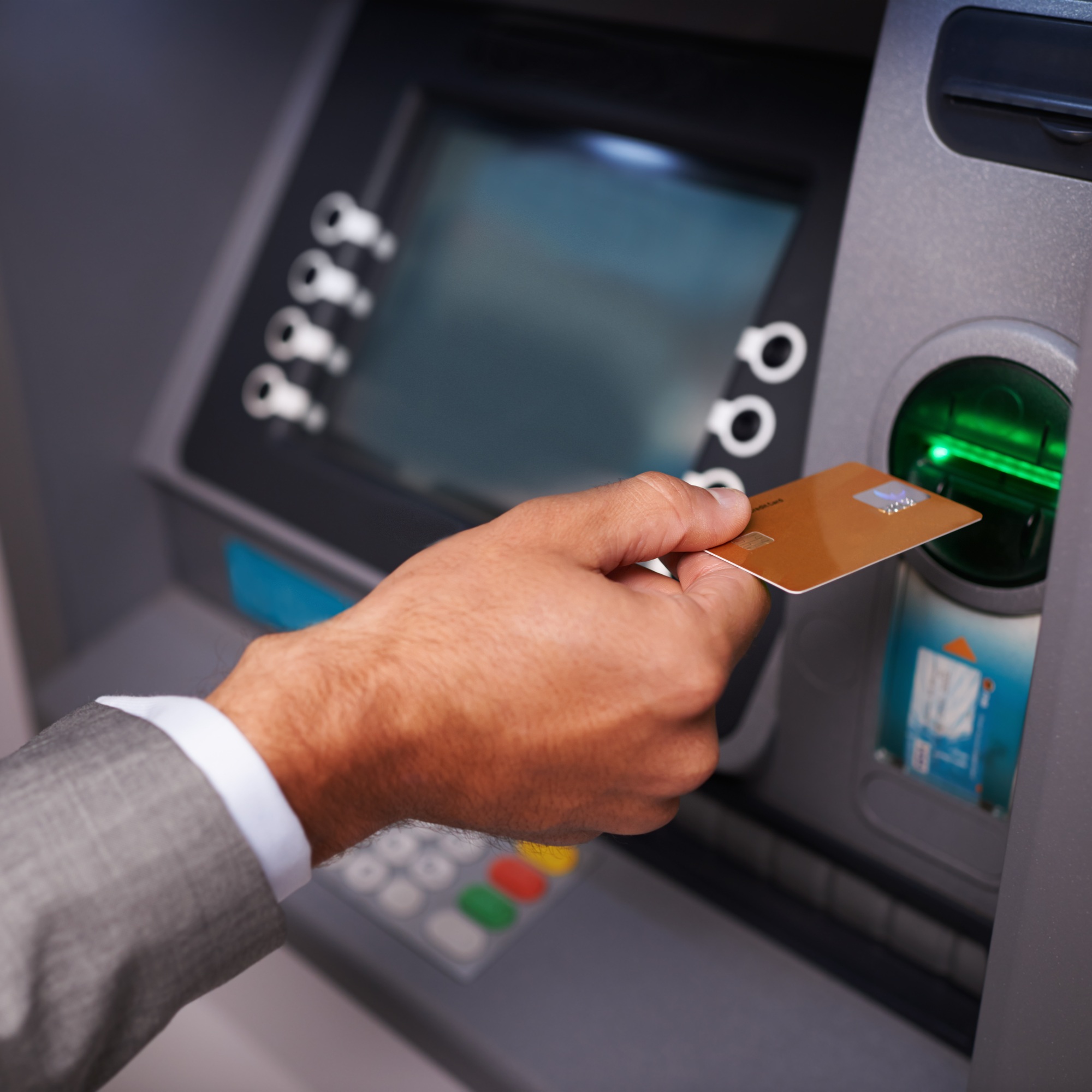 Need some cash. Cropped shot of a businessman inserting his bank card at an ATM.
